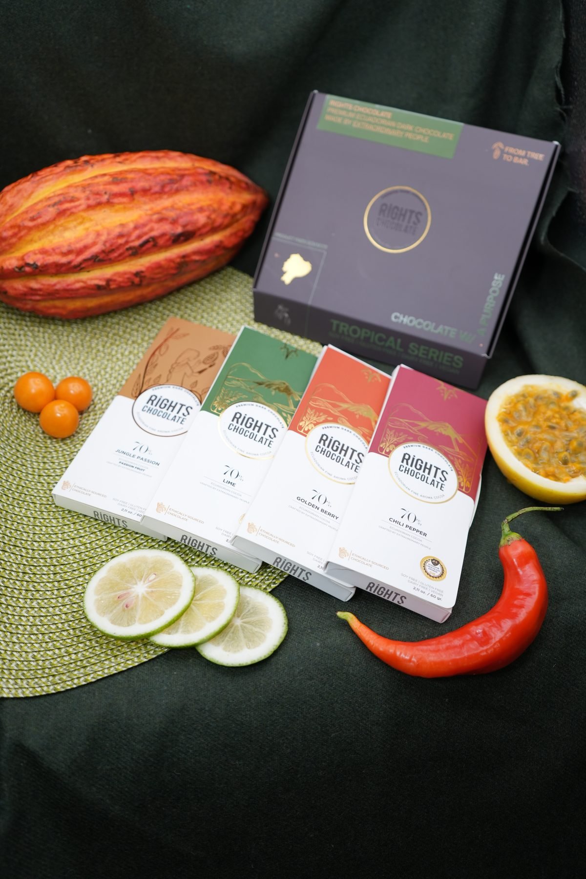 Caja de regalo Rights con cinco barras, mazorca de cacao, limón y ají sobre tela verde