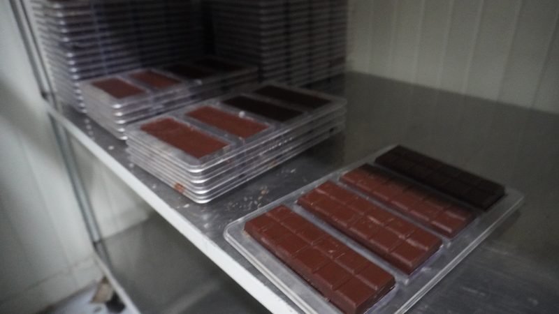 Carro con moldes llenos de chocolate en la planta