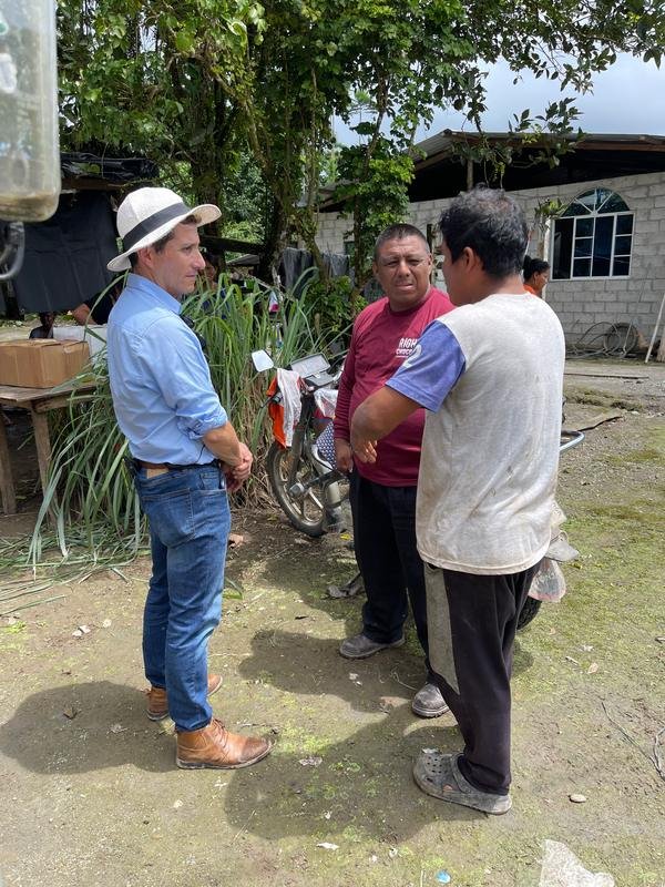 Cacaocultores conversando frente a la casa de la finca