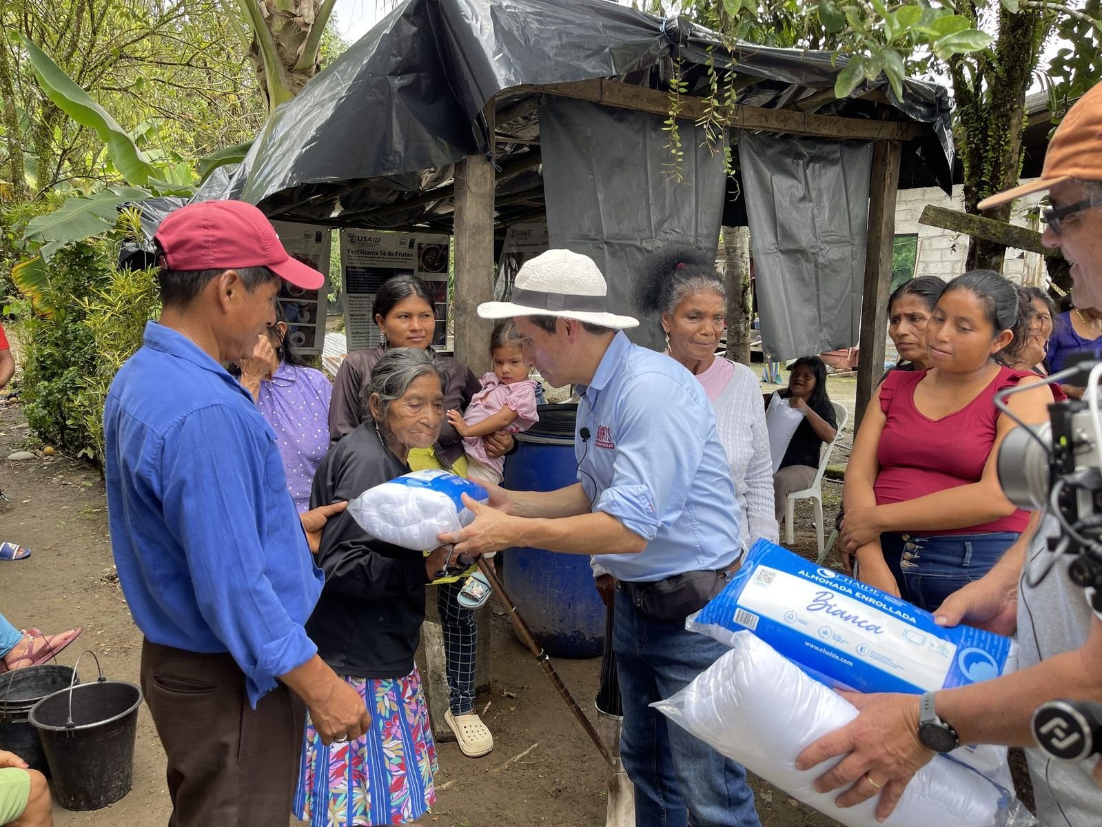 Entrega de un paquete de asistencia a una beneficiaria de la comunidad