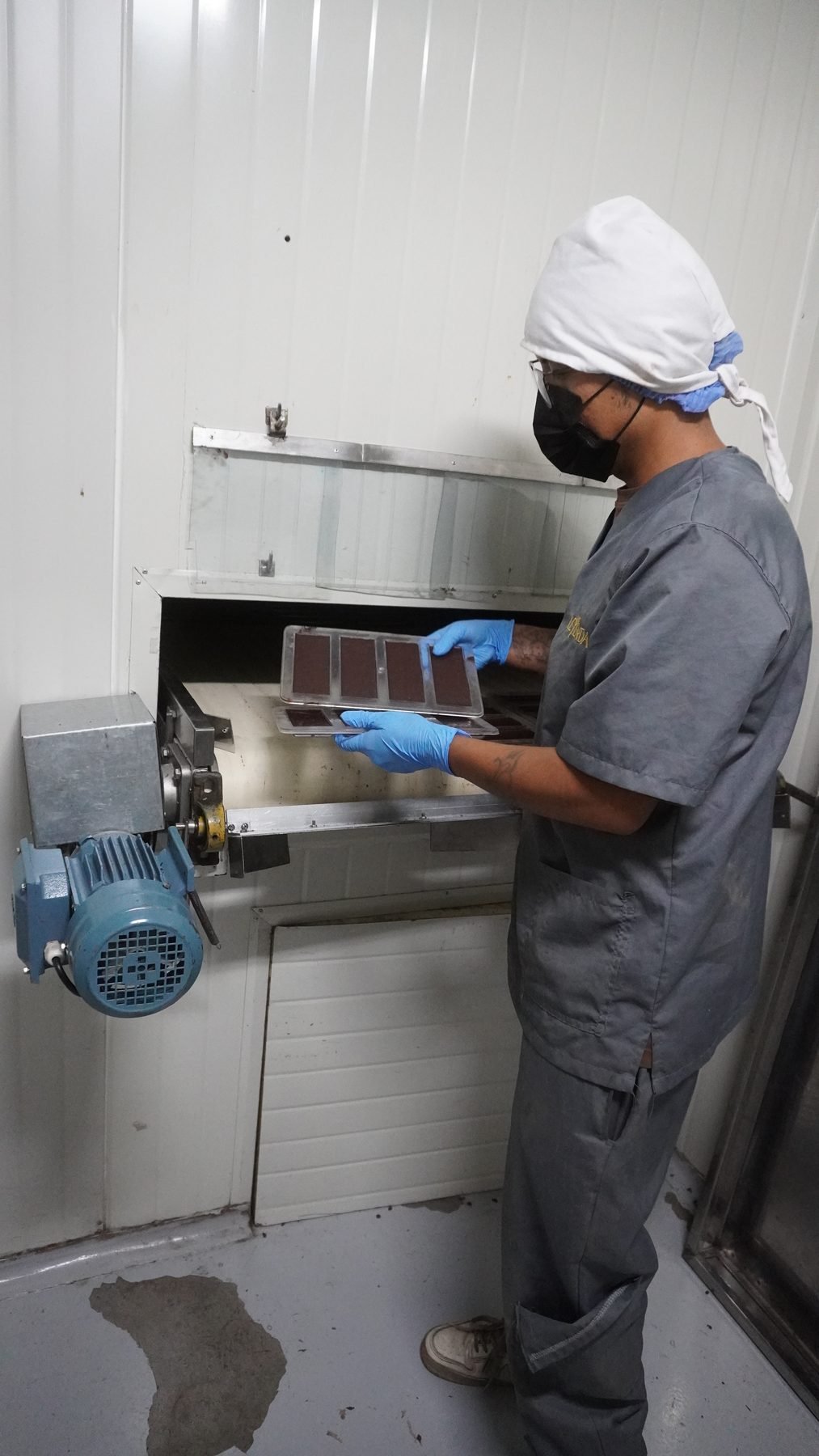 Operaria con cofia y mascarilla en la máquina de moldeado de la planta Rights