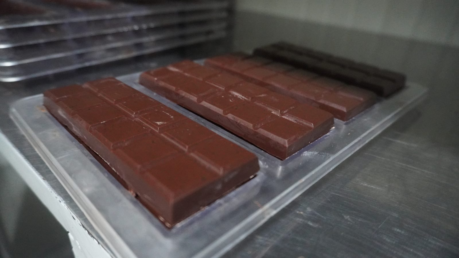 Barras de chocolate recién desmoldadas sobre la mesa de la planta